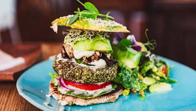 Raw vegan burger on a blue ceramic plate