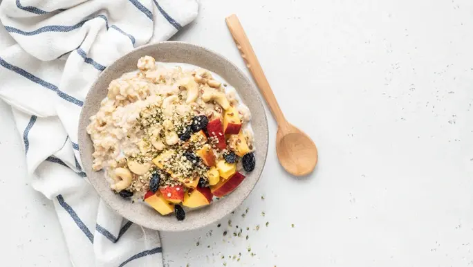 Breakfast bowl with oats, cashew nuts, nectarines, blueberries and hemp seeds