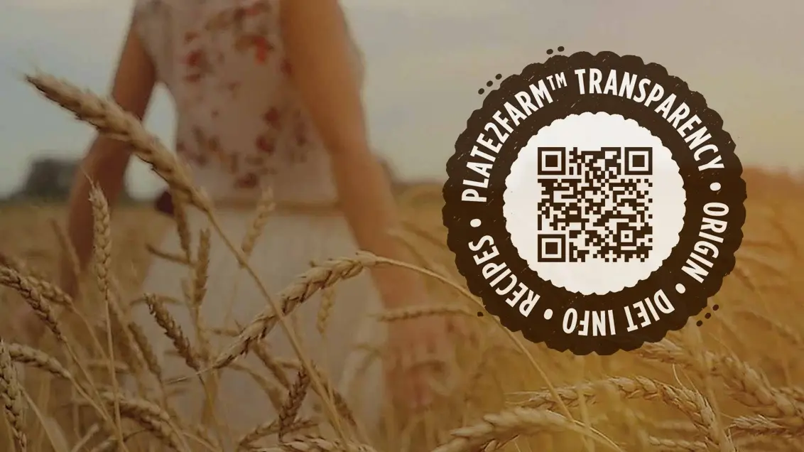 A Plate2Farm logo and QR code on a picture of a woman walking through a wheat field