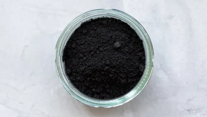 Powdered charcoal in a glass ramekin