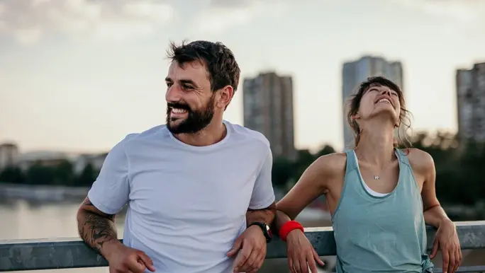 Happy couple relaxing and smiling after an outdoor workout