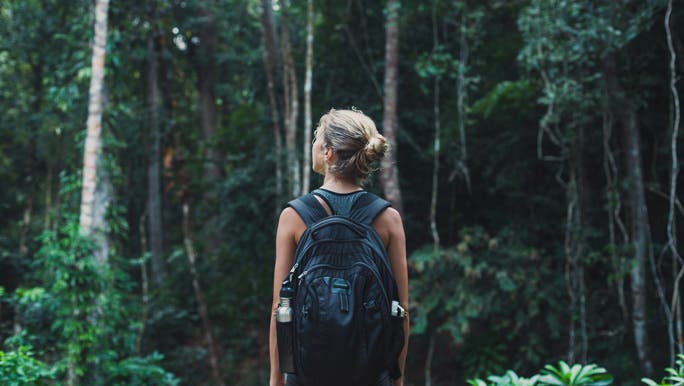 Woman walking in the bush stopping to take her surroundings