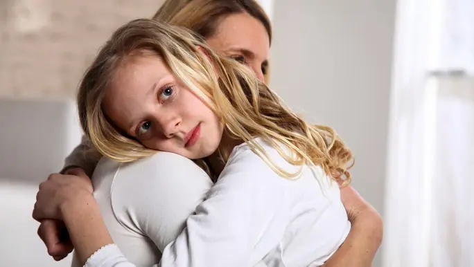 Mum giving her daughter a comforting hug
