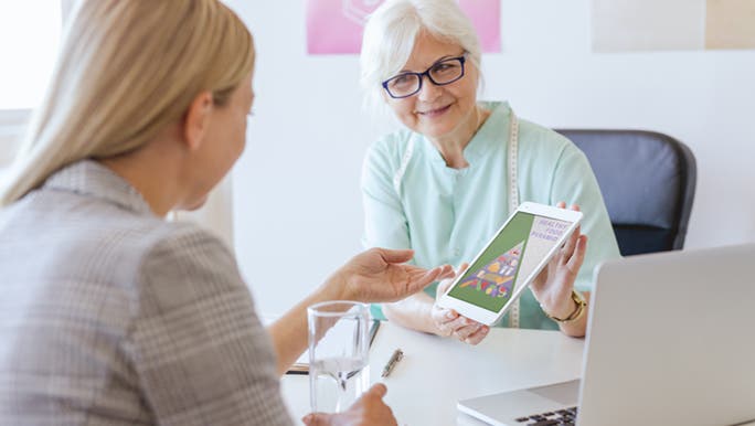 A dietitian and her patient, sitting in her office. The dietitian is explaining to her the differences between what wheat and gluten intolerances are.