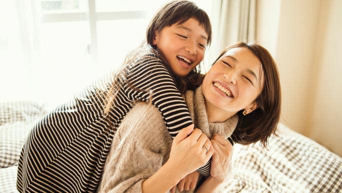 Young mum playing and enjoying time with her daughter at home