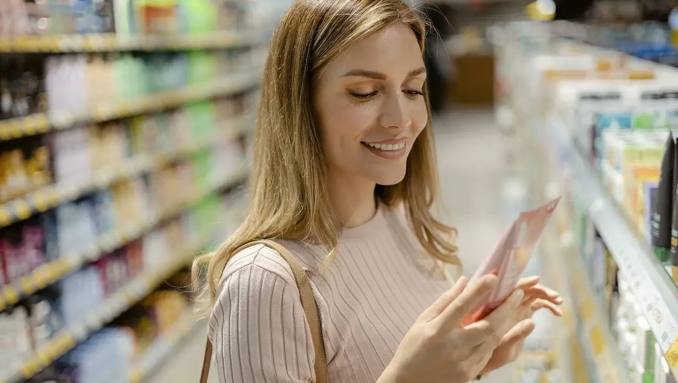 Women checking the ingredients on the back of a skincare products