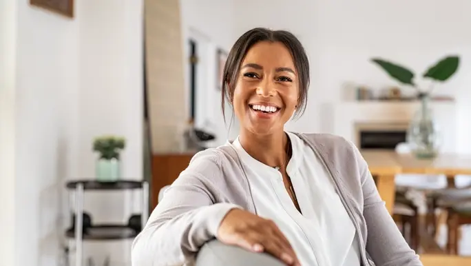Healthy woman smiling towards the camera in her living room.