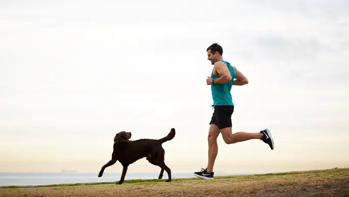Sam Wood jogging outdoors with his dog