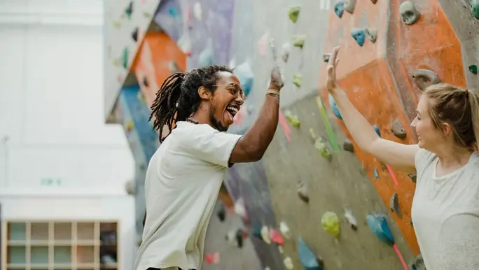 Climbing partners high five in the climbing gym