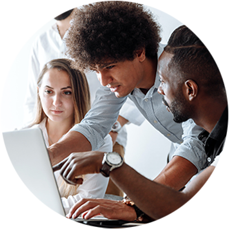 Round photo of two men and a woman huddled around a computer, pointing at the screen and discussing what they see