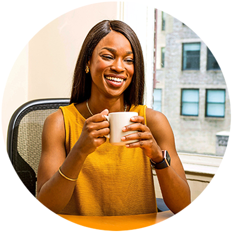 Round photo of a smiling woman with long, black hair, wearing a gold-colored sleeveless top and drinking a cup of coffee