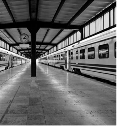 A vintage train station captured in black and white.