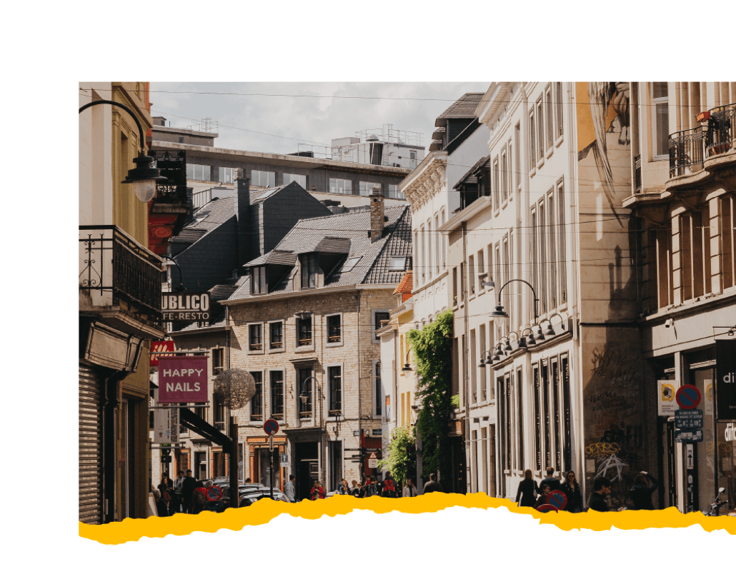 A bustling city street with tall buildings & people strolling along the sidewalks. A bustling city street with tall buildings & people strolling along the sidewalks.