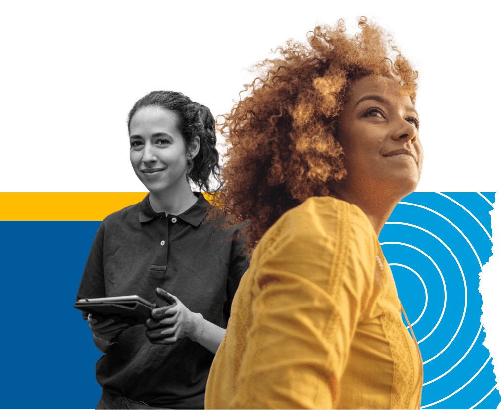 A woman in yellow blouse looking up. Another woman smiling at the background & holding a tablet. 