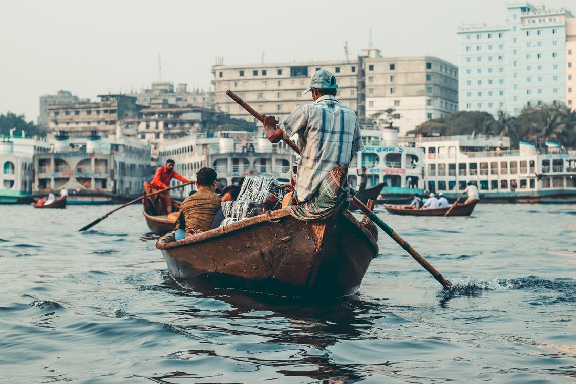 People rowing a boat in Dhaka, Bangladesh. People rowing a boat in Dhaka, Bangladesh.