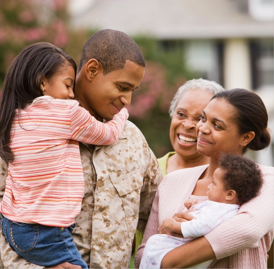 A soldier with his family, showcasing happiness in their reunion. A soldier with his family, showcasing happiness in their reunion.