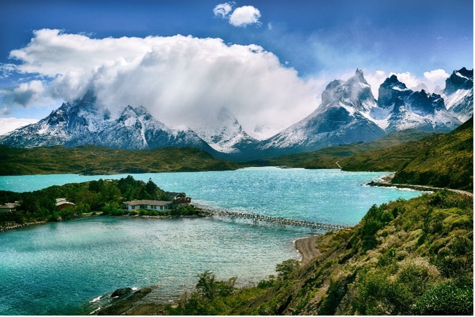 A crystalline lake sits in front of snowcapped mountains in Torres del Paine National Park, Chile.