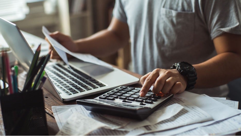 Man sitting at a desk using a calculator