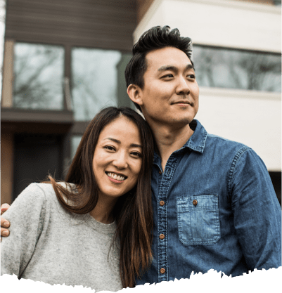 A woman and man in front of their house.