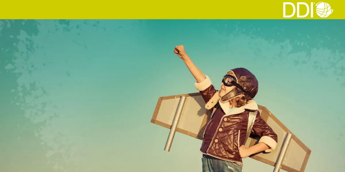 a little boy wearing an aviator hat and wings