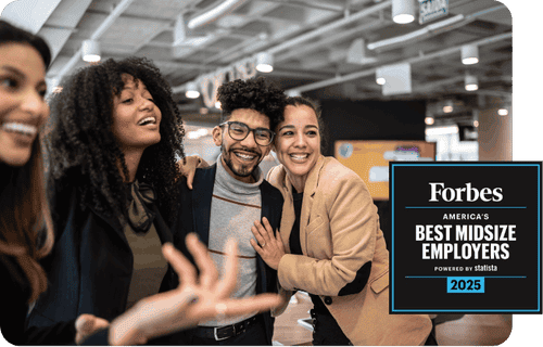 Vier Menschen, die in einem professionellen Umfeld zusammenarbeiten und lächeln. Eine Person gestikuliert enthusiastisch, während sie spricht