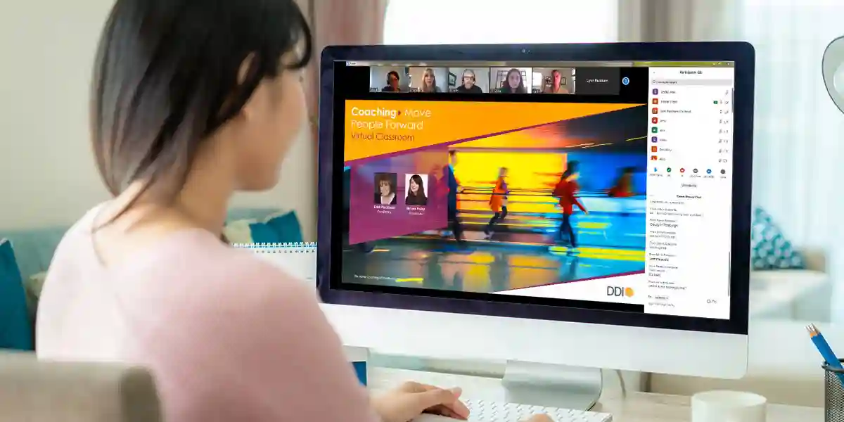 Frau mit DDI-Website für virtuelles Klassenzimmer, die auf ihrem Desktop-Computer geöffnet ist