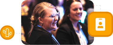 Two women in business attire smiling and listening during the Summit, with icons overlaid on the right and left - one a cactus, and the other a badge.