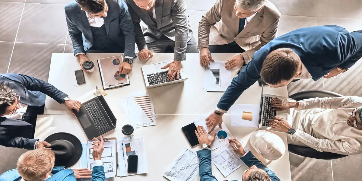 a team of business people working together with their laptops around a table