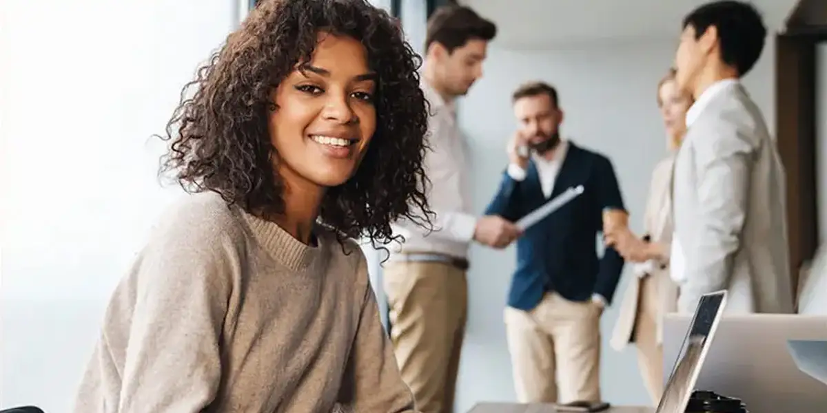 Leader de niveau intermédiaire souriant à la caméra après son programme de développement du leadership de niveau intermédiaire