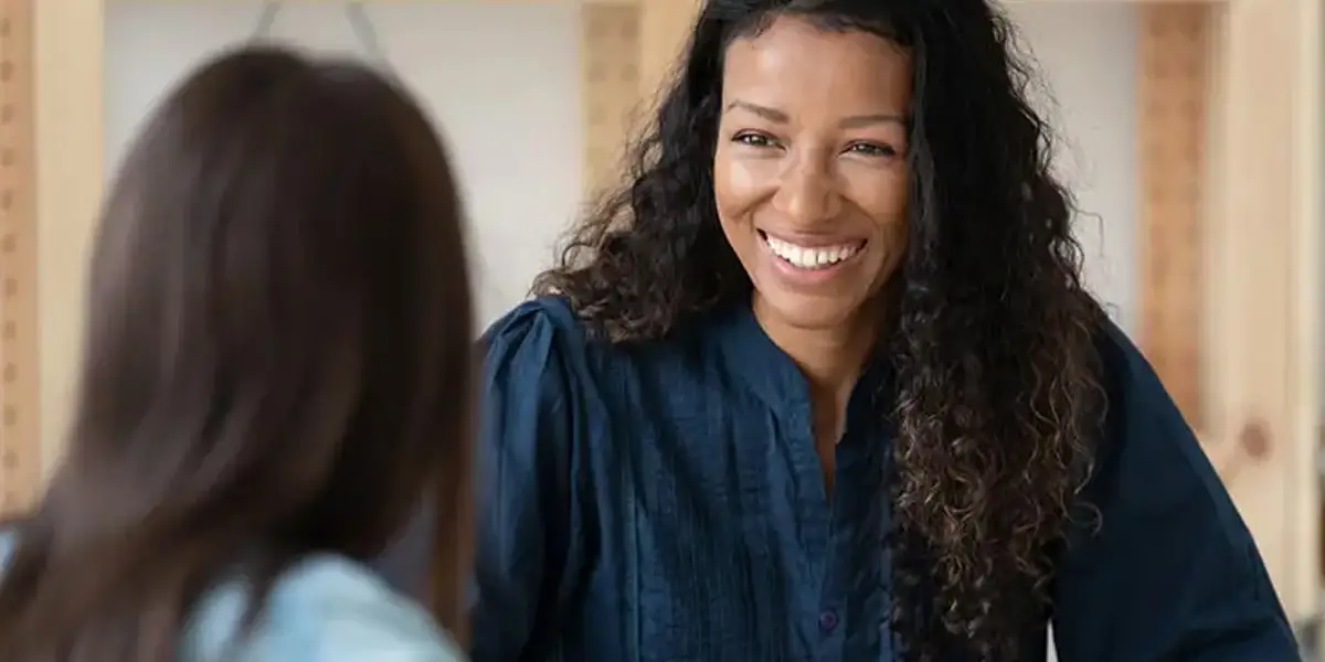 une dirigeante souriante coachée professionnellement par son coach exécutif DDI