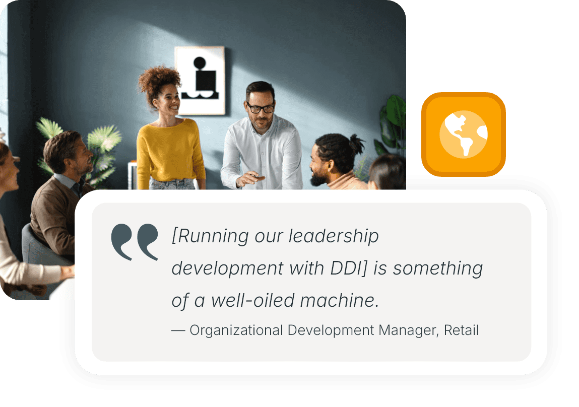 A group of colleagues collaborating around a table with laptops, notebooks, and mugs.