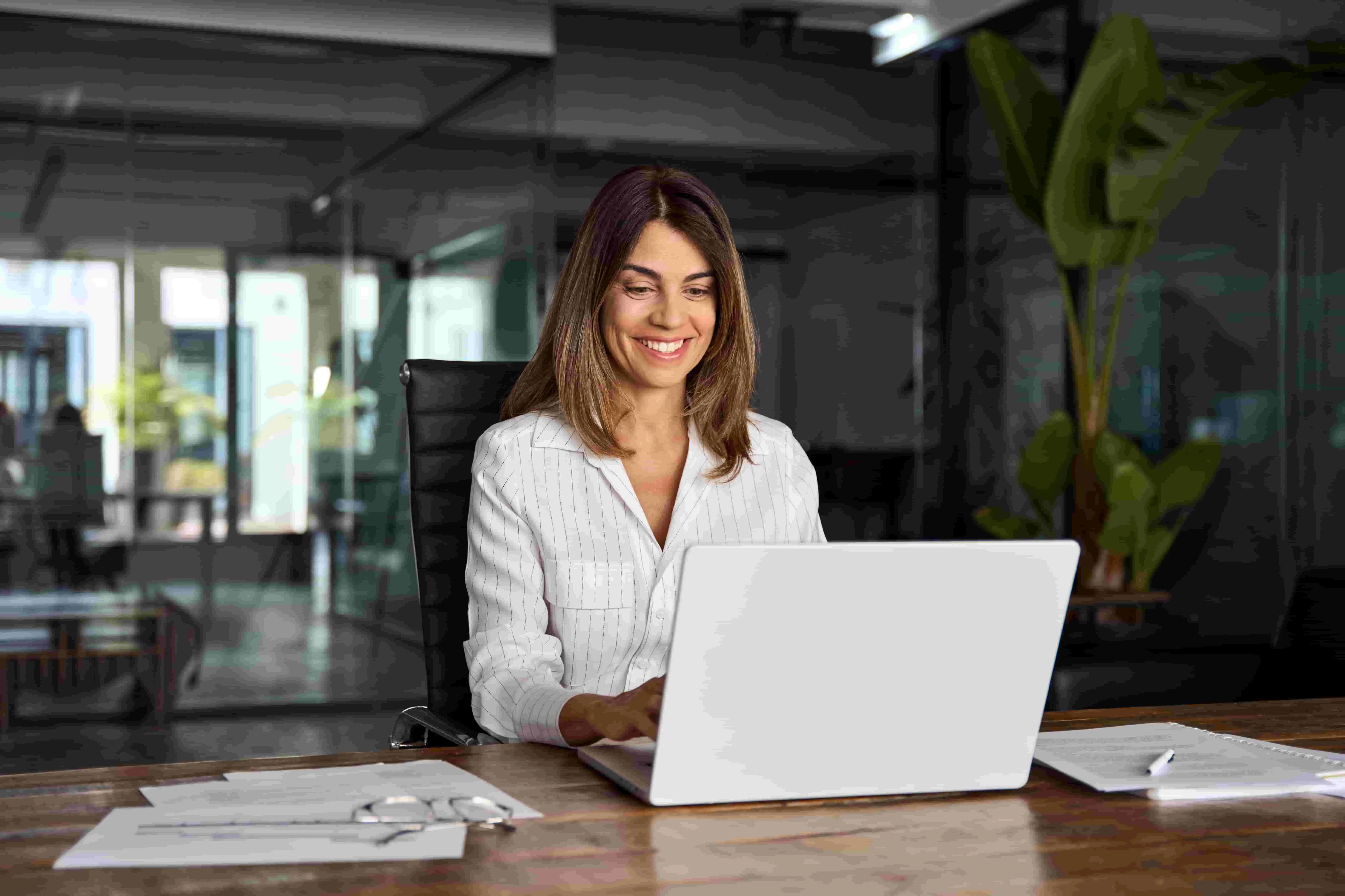 smiling woman leaders working on her laptop