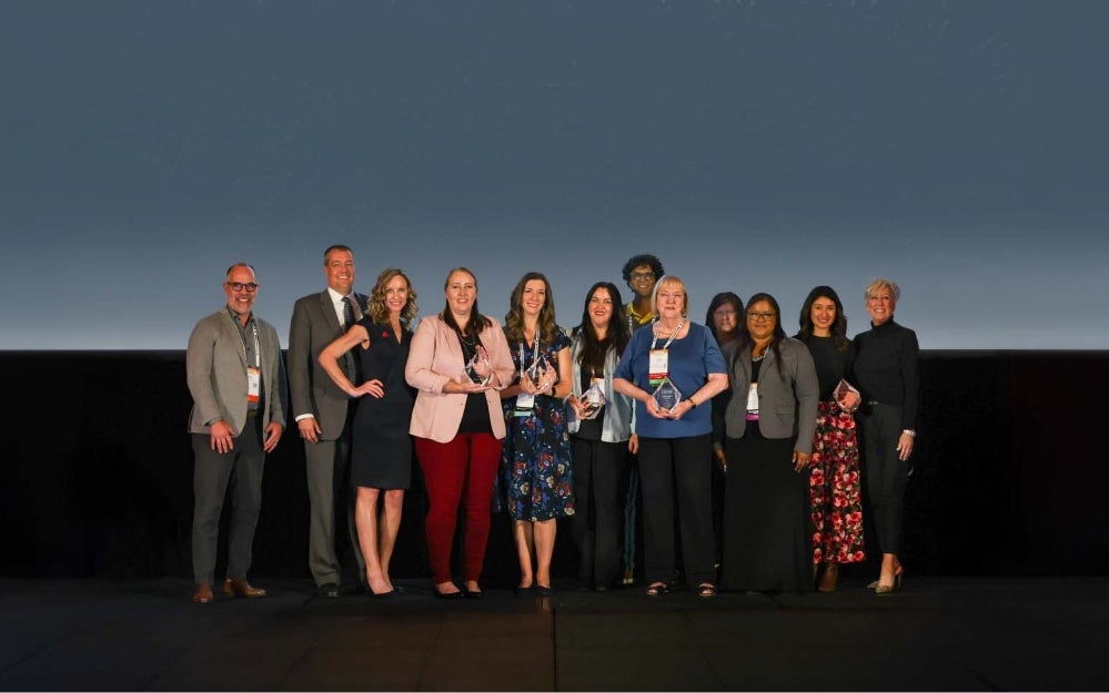 Group of award recipients posing on a stage with an overlay reading “2025 Customer Awards Winners.”