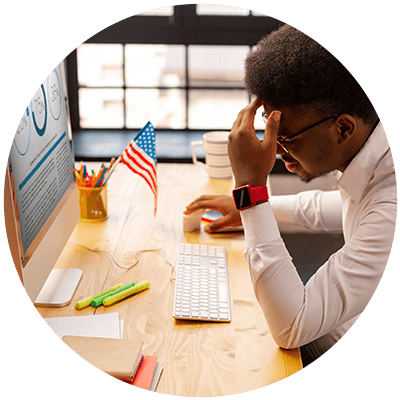 a business professional looking down at his computer keyboard, frustrated, to show that one other reason why leadership development fails is when companies overvalue the role of technology in their programs