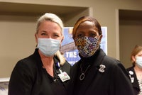 Two females posing for the camera in front of the beam