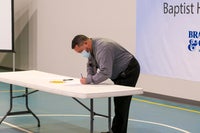 Man signing a document on a table