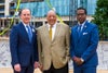 Mark Faulkner President and Chief Executive Officer Baptist Health Care with guests taking picture in front of topping off beam.