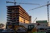 A shot of the building with two cranes