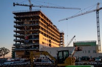 A shot of the building with two cranes