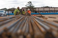 A photo shot down the side of rebar with men in the background