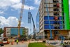 Crane lifting metal piece in front of new Baptist Hospital.