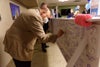 A man signing the beam with a blue sharpie