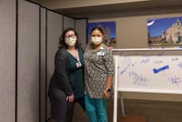Team members pose in front of beam signing event.