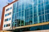 Front view of new campus building with wall of glass panels.