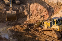Construction digger vehicles digging dirt.