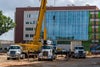 Front view of new hospital with crane in front.