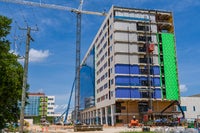 Construction of exterior of new campus with crane.
