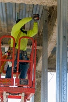 Worker screwing in metal