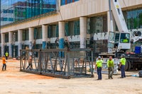 Crew with crane ready to pull up metal piece.