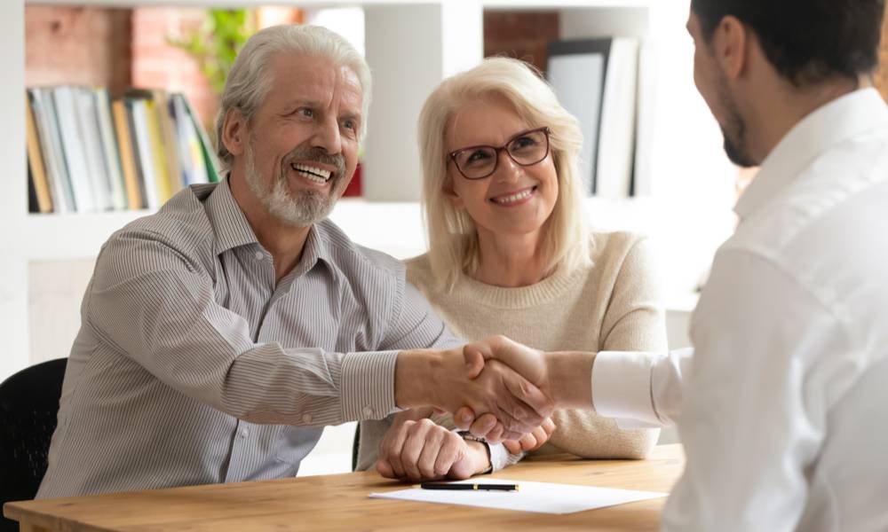 Happy senior old family couple clients make financial insurance estate business deal handshake agent lawyer.jpg